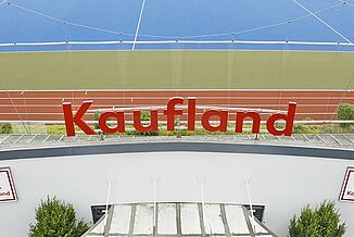 Kaufland Logo vor einer REGUPOL Laufbahn
