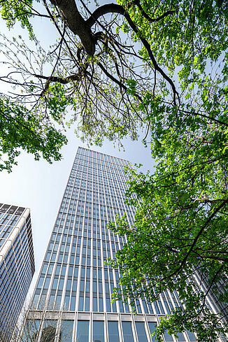Außenansicht vom Mixed-Use Hochhaus Marienturm in Frankfurt mit einem Baum davor.