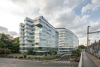 Ein Gebäude mit Glasfassade der BRED Bank wurde direkt  direkt an den Bahnschienen in Joinville-le-Pont Paris gebaut.