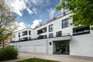 Moderner Gebäudekomplex in München mit Wohnungen und einem Edeka Supermarkt.