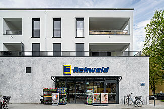 Edeka Supermarkt in einem Neubau in München mit darüberliegenden Wohnungen.
