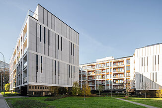 Wohngebäude Piano House in Warschau mit begrüntem Innenhof und Sitzbänken.