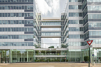 Eingangsbereich des Mixed-Use Gebäudes West Plaza mit Glasfassade.