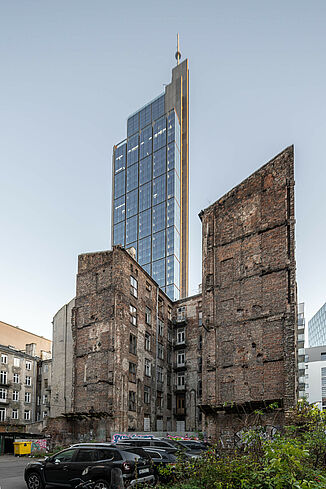Im Vordergrund steht eine Bauruine und dahinter sieht man den Varso Tower in Warschau.