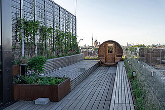 Kalles Dachterrasse mit Saunafass, gemütlichen Sitzgelegenheiten und modernem Ambiente ist ideal für entspannte Wellness-Momente im Freien.