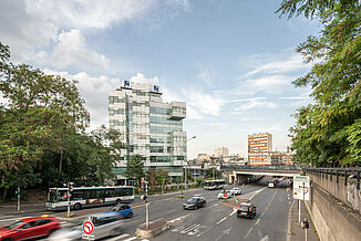 Eine viel befahrene Straße in Paris mit einem Bürokomplex der BRED Bank im Hintergrund.