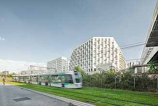 Mixed-Use Gebäude Rosa Park in Paris mit vorbeifahrender Straßenbahn.