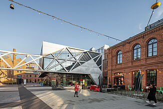 Im Mixed-Use Projekt Koneser in Warschau sieht man einen Mix aus alten Backsteinhäusern und moderner Architektur aus Glas und Stahl.