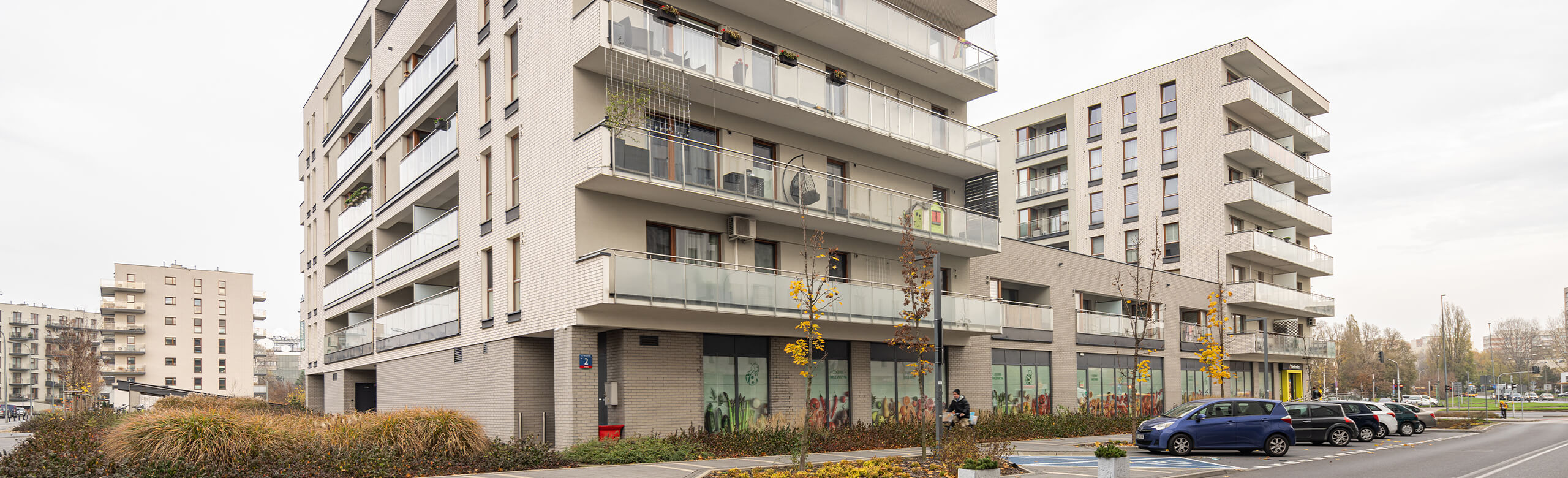 Building complex in Warsaw with residential units and a Biedronka supermarket on the ground floor.